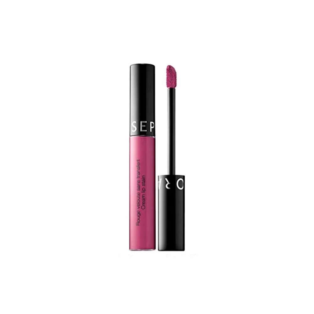 Pink lip gloss with black applicator on a white background