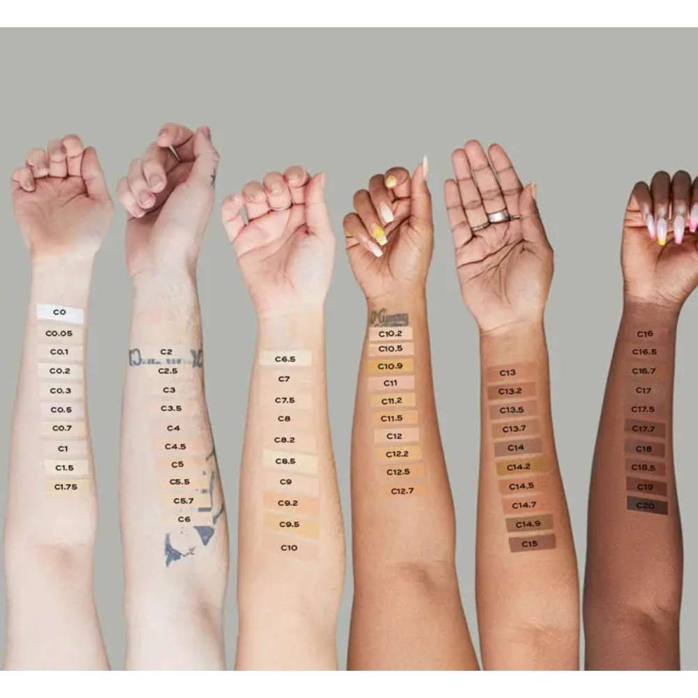 Multiple hands with color swatches on skin tones against a neutral background