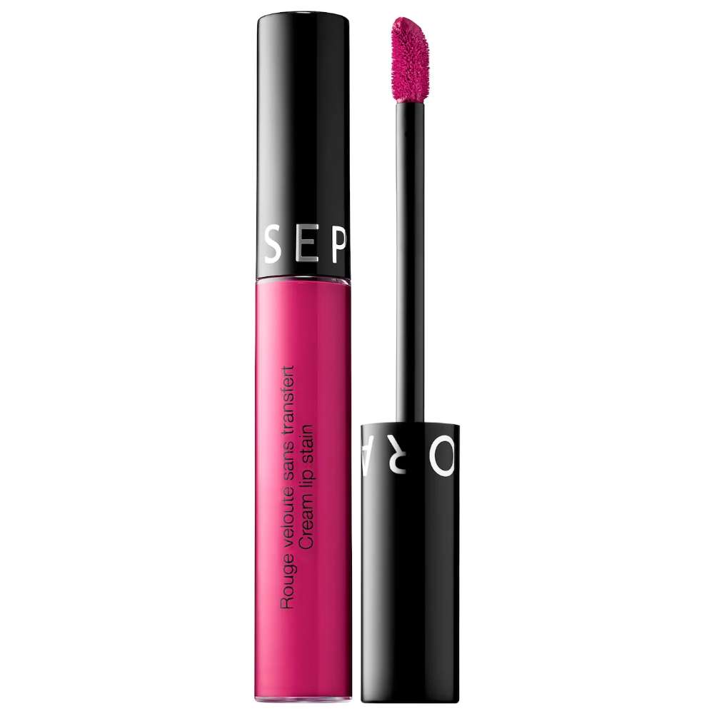 Pink lip stain with black applicator on a white background