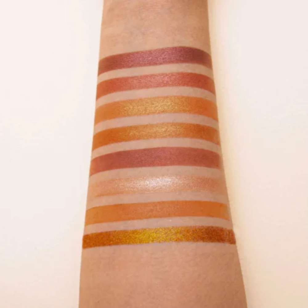 Color swatches of lipsticks on a person's arm with a neutral background
