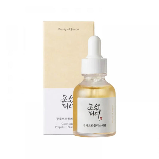 A bottle of Beauty of Joseon Glow Serum with a dropper, next to its packaging box. The bottle is translucent with a yellowish liquid inside, and the label has Hangul (Korean script) text.