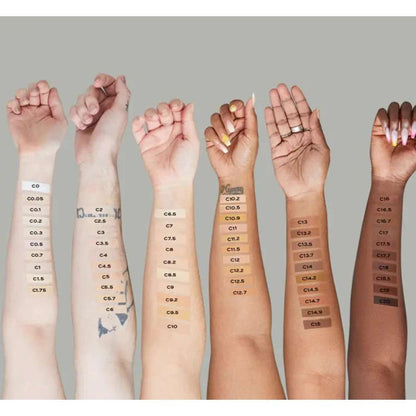 Multiple hands with color swatches on skin tones against a neutral background